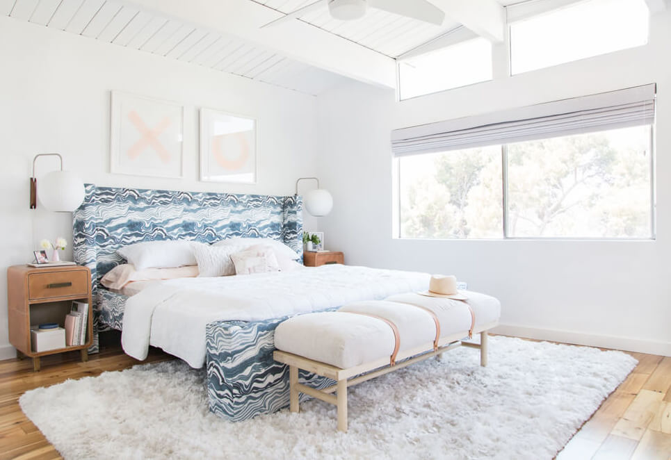 Upholstered headboard in patterned linen, with maple bench at the foot of the bed
