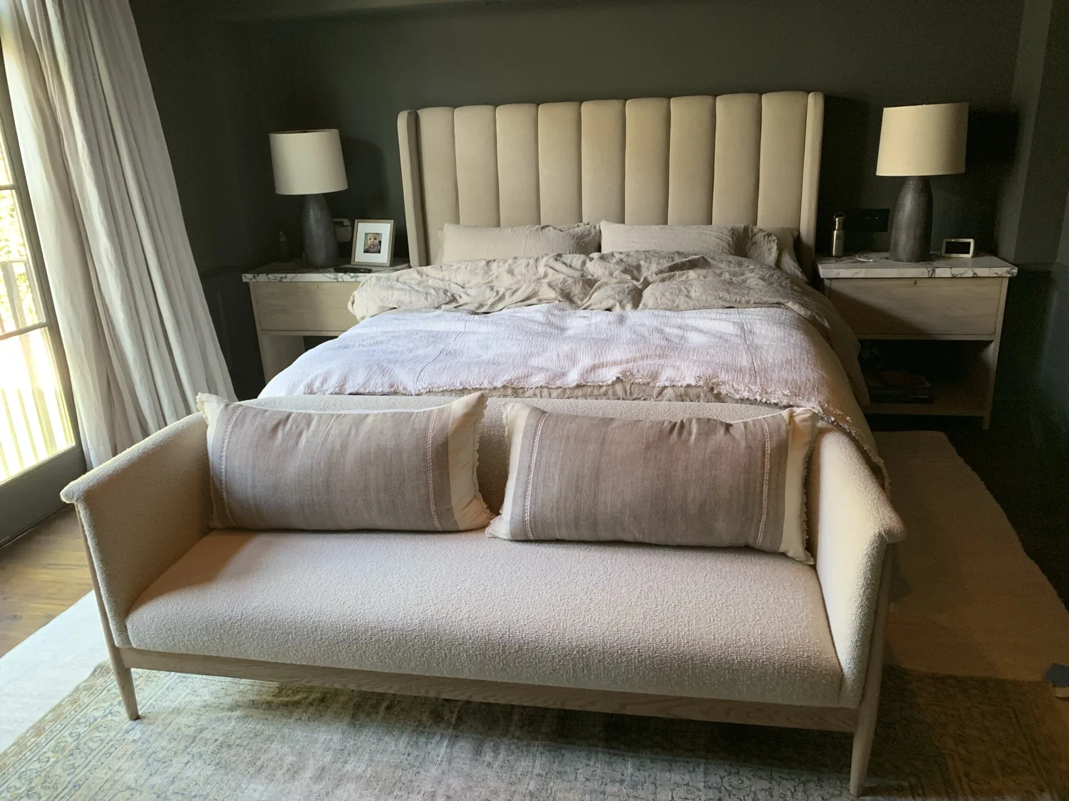 A channel-tufted upholstered bed with matching nightstands installed in a finished bedroom